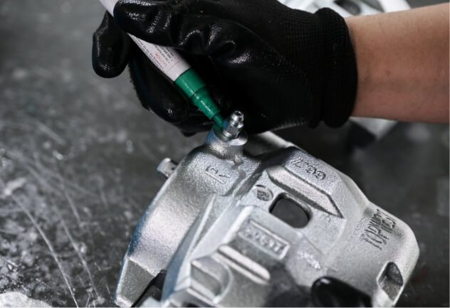 Final inspection of a brake caliper by a QC inspector